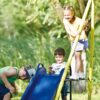 LN20232278 Metal Outdoor Swing Set with Climbing Wall, Cover, Swing, and Tower Steel Frame, Swing n' Slide, Basketball Hoop